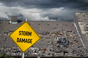 Storm damage sign in front of roof that requires roof replacement
